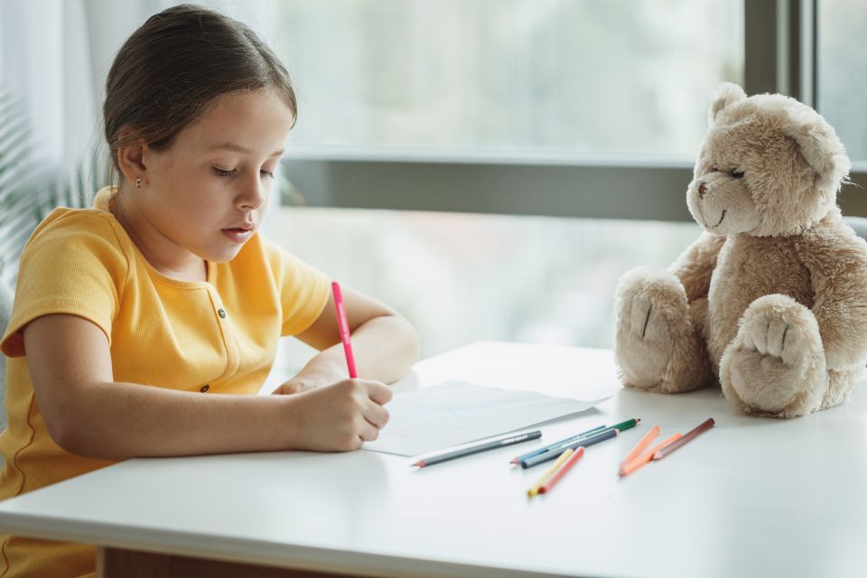 A student working through a homework book at a desk