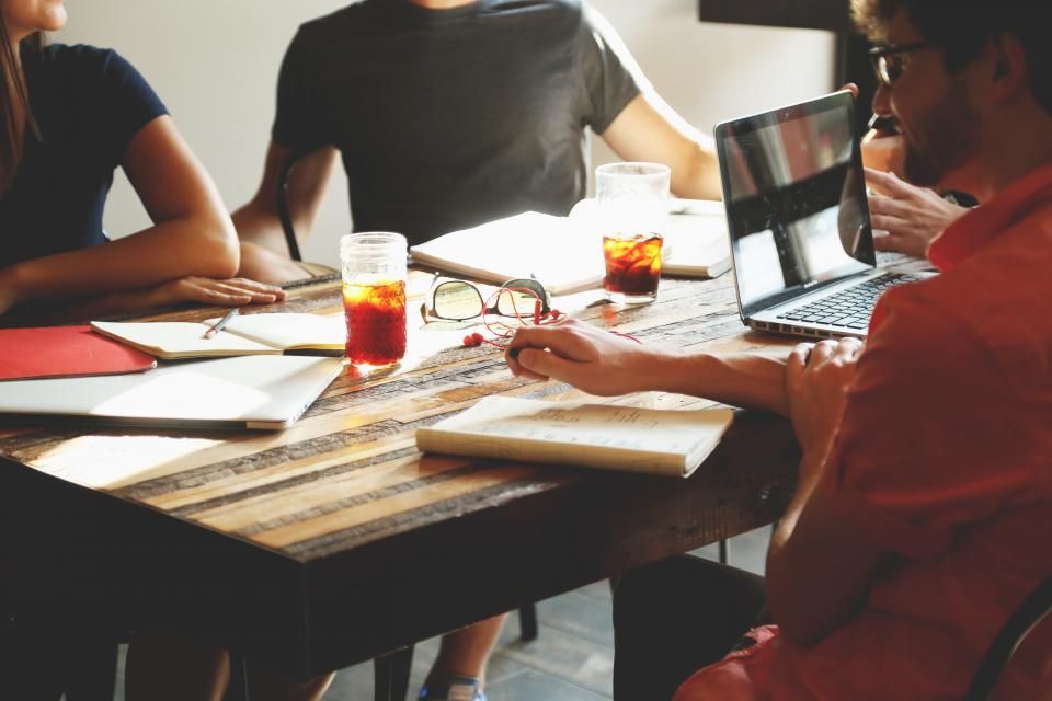 A team gathered around a table reviewing work